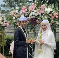 Aisyah tampak malu sembari menutupi wajahnya saat ingin mencium tangan suaminya. Ustaz Agam sendiri tampak malu dan kikuk. Sampai-sampai pembawa acara menyuruhnya menggandeng Aisyah.  Foto: Dok. Instagram @ajeng_luthfiareal.