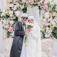 Video memperlihatkan tampak salah satu wanita bercadar hitam mengarahkan tangan Ustaz Agam agar menggandeng Aisyah. Keduanya lalu berjalan menuju area pelaminan. Foto: Dok. Instagram @aisyahvier.