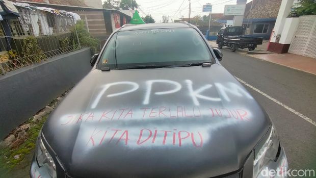 Pria di Kuningan coret-coret mobil mewahnya dengan tulisan bernada protes penerapan PPKM Darurat.