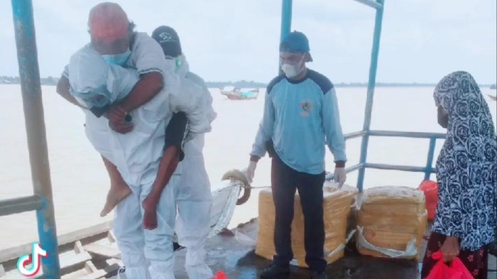 Video polisi menggendong pasien suspek COVID-19 dan menyeberangi sungai di Indragiri Hilir, Riau, viral. Aksi itu dilakukan karena pasien mengalami sesak nafas. (dok Istimewa)