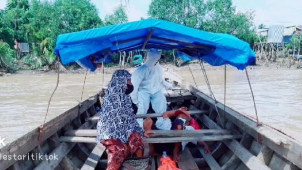 Video polisi menggendong pasien suspek COVID-19 dan menyeberangi sungai di Indragiri Hilir, Riau, viral. Aksi itu dilakukan karena pasien mengalami sesak nafas. (dok Istimewa)