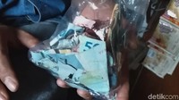 Uang itu dibungkus plastik dan ia simpan di etalase. Yadi mengaku tak pernah melihat dan mengambil uang itu lantaran khawatir terpakai untuk kebutuhan sehari-hari. Dia sudah berupaya menukar uang itu ke bank. Namun uang itu tidak diterima pihak bank lantaran kondisinya rusak.