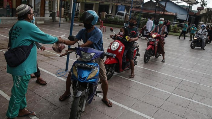 Panitia membagikan daging kurban kepada warga secara 'drive thru' di Masjid Raya Nurul Islam, Palangkaraya, Kalimantan Tengah, Selasa (20/7/2021). Pembagian daging kurban pada Hari Raya Idul Adha 1442 H dengan cara 'drive thru' dipilih panitia masjid tersebut sebagai cara untuk menghindari kericuhan dan kerumunan warga di masa pandemi COVID-19. ANTARA FOTO/Makna Zaezar/wsj.