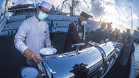 Perwira Pelaksana (Palaksa) KRI Bima Suci Mayor Laut (P) Sugeng Hariyanto (kedua kiri) bersama Kadep Senbah Kapten Laut (P) Rizky Prima Afristya Putra (kiri) dan prajurit KRI Bima Suci makan bersama usai melakukan salat Idul Adha 1442 H di Dermaga Armada II, Surabaya, Jawa Timur, Selasa (20/7/2021).  