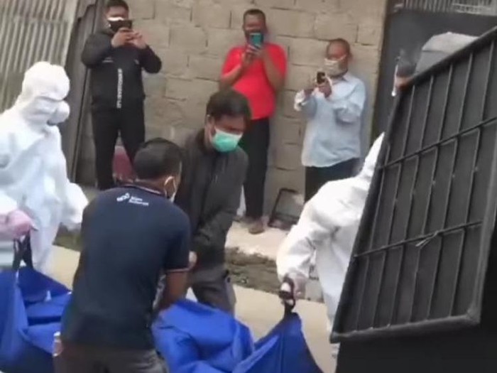 Petugas ber-APD gotong jenazah dari salah satu kontrakan di Bekasi (tangkapan layar)
