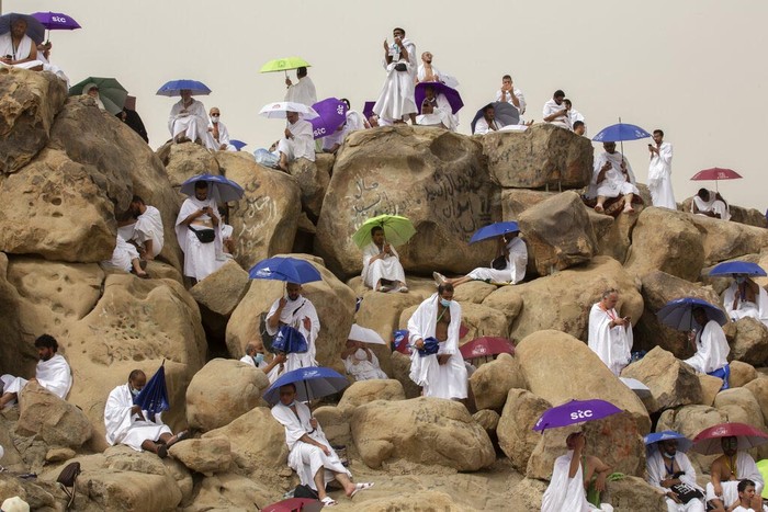 A Muslim pilgrim prays on top of the rocky hill known as the Mountain of Mercy, on the Plain of Arafat, during the annual hajj pilgrimage, near the holy city of Mecca, Saudi Arabia, Monday, July 19, 2021. The coronavirus has taken its toll on the hajj for a second year running. What once drew some 2.5 million Muslims from all walks of life from across the globe, the hajj pilgrimage is now almost unrecognizable in scale. (AP Photo/Amr Nabil)
