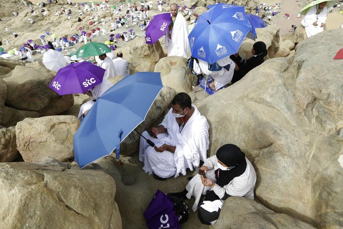 A Muslim pilgrim prays on top of the rocky hill known as the Mountain of Mercy, on the Plain of Arafat, during the annual hajj pilgrimage, near the holy city of Mecca, Saudi Arabia, Monday, July 19, 2021. The coronavirus has taken its toll on the hajj for a second year running. What once drew some 2.5 million Muslims from all walks of life from across the globe, the hajj pilgrimage is now almost unrecognizable in scale. (AP Photo/Amr Nabil)