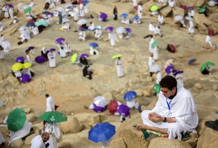 A Muslim pilgrim prays on top of the rocky hill known as the Mountain of Mercy, on the Plain of Arafat, during the annual hajj pilgrimage, near the holy city of Mecca, Saudi Arabia, Monday, July 19, 2021. The coronavirus has taken its toll on the hajj for a second year running. What once drew some 2.5 million Muslims from all walks of life from across the globe, the hajj pilgrimage is now almost unrecognizable in scale. (AP Photo/Amr Nabil)