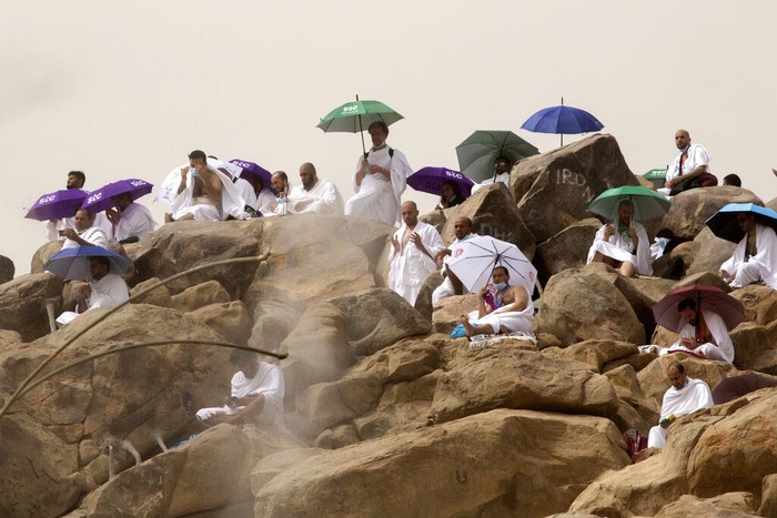 A Muslim pilgrim prays on top of the rocky hill known as the Mountain of Mercy, on the Plain of Arafat, during the annual hajj pilgrimage, near the holy city of Mecca, Saudi Arabia, Monday, July 19, 2021. The coronavirus has taken its toll on the hajj for a second year running. What once drew some 2.5 million Muslims from all walks of life from across the globe, the hajj pilgrimage is now almost unrecognizable in scale. (AP Photo/Amr Nabil)
