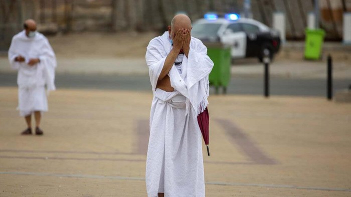 A Muslim pilgrim prays in front of the rocky hill known as Mountain of Mercy, on the Plain of Arafat, during the annual hajj pilgrimage, near the holy city of Mecca, Saudi Arabia, Monday, July 19, 2021. Tens of thousands of vaccinated Muslim pilgrims circled Islam's holiest site in Mecca on Sunday, but remained socially distanced and wore masks as the coronavirus takes its toll on the hajj for a second year running. What once drew some 2.5 million Muslims from all walks of life from across the globe, the hajj pilgrimage is now almost unrecognizable in scale. (AP Photo/Amr Nabil)