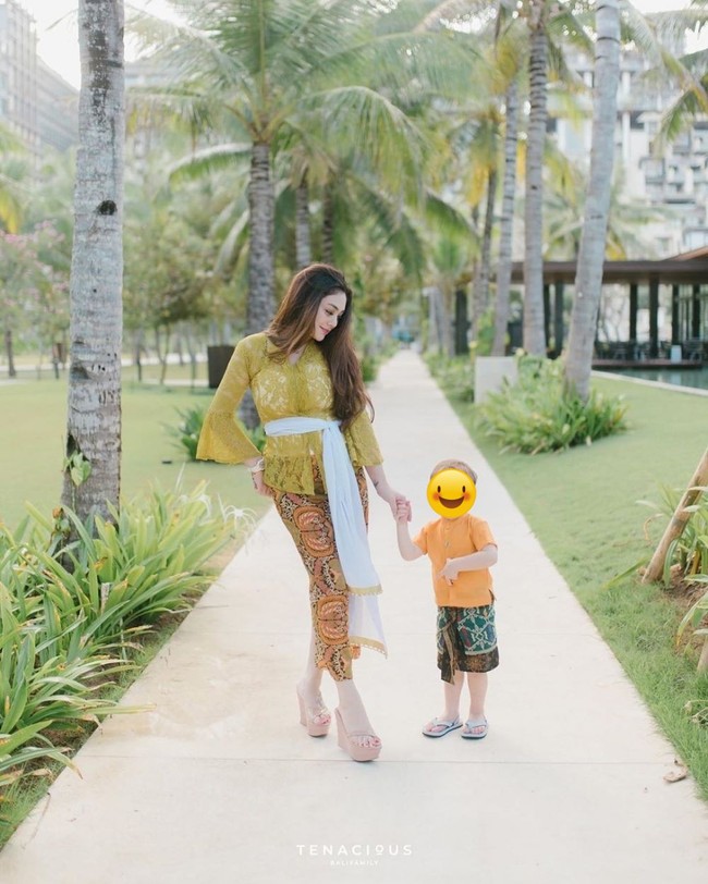 Berfoto bersama sang anak, Celine Evangelista tampak cantik mengenakan kebaya Bali. Dengan kebaya kuning dan kain bawahan berwarna senada, Celine terlihat mempesona. Foto: Instagram
