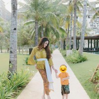 Berfoto bersama sang anak, Celine Evangelista tampak cantik mengenakan kebaya Bali. Dengan kebaya kuning dan kain bawahan berwarna senada, Celine terlihat mempesona. Foto: Instagram