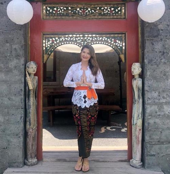 Kini menetap di Bali, artis blasteran Polandia, Tamara Bleszynski, juga kerap mengenakan kebaya khas Bali. Begini penampilannya saat mengenakan kebaya Bali berwarna putih dan kain ikat pinggang oranye. Foto: Instagram