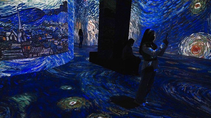 Dubai Mall A woman takes a photograph at the Infinity des Lumieres digital art gallery at Dubai Mall in Dubai, United Arab Emirates, Monday, July 12, 2021. Infinity des Lumieres uses digital projectors to play moving images of artwork across a massive gallery. This image incorporates