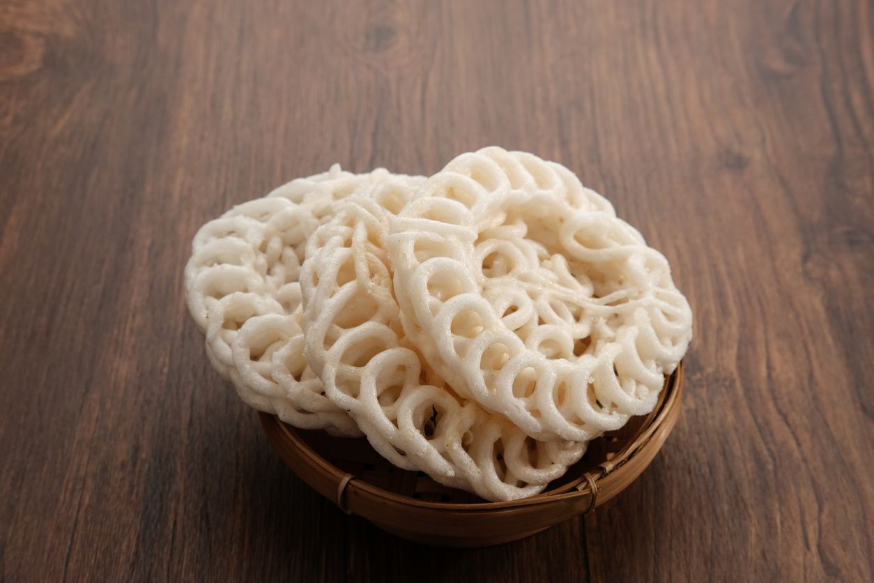 Krupuk or Kerupuk, Indonesia traditional crackers, served in bamboo plate on wooden table.