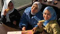 Berada di luar negeri, Bella dan kedua temanya tampak berada di sebuah restoran pinggir danau sambil menikmati kue. Foto: Instagram @laudyacynthiabella