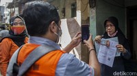  Petugas mengecek data warga yang menerima bantuan tunai.