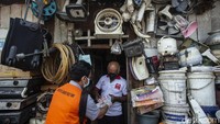 Petugas menyusuri gang-gang sempit di kawasan Kebon Jahe untuk menyalurkan bantuan tunai.
