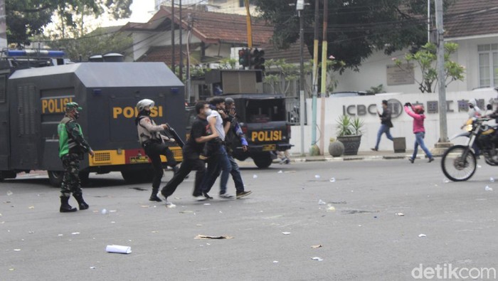 Polisi membubarkan massa aksi penolak Pemberlakuan Pembatasan Kegiatan Masyarakat (PPKM) yang menduduki persimpangan Dago-Sulanjana, Bandung.