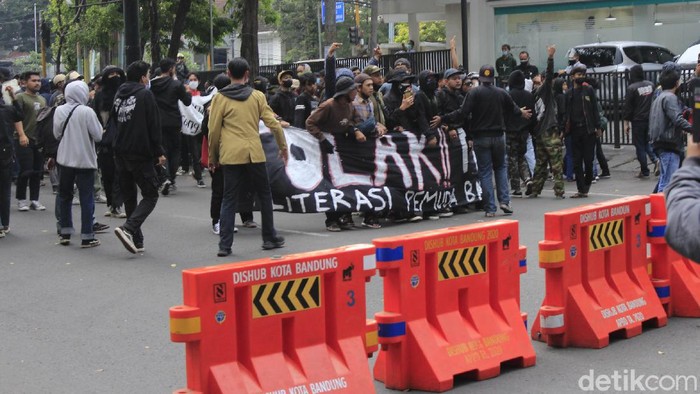 Polisi membubarkan massa aksi penolak Pemberlakuan Pembatasan Kegiatan Masyarakat (PPKM) yang menduduki persimpangan Dago-Sulanjana, Bandung.