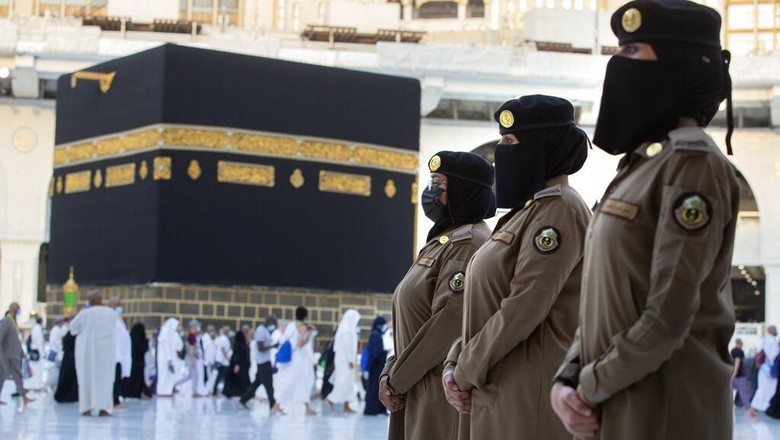 Potret Polisi Wanita Saudi Siaga Awasi Haji di Makkah Saudi police woman, Bashair, left, adjusts the veil of her colleague Alaa, as they recently deployed to the service at the Grand Mosque, during the annual hajj pilgrimage, in the Saudi Arabias holy city of Mecca, Tuesday, July 20, 2021. (AP Photo/Amr Nabil)