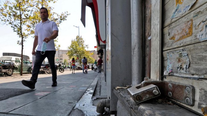 An Iranian man walks past a shuttered store in the capital Tehran, on July 20, 2021, as authorities tighten restrictions amid the COVID-19 pandemic. - Iran a day earlier announced strict curbs in the capital Tehran and a nearby province to stem the spread of COVID-19, as daily infections drew close to an all-time high. (Photo by ATTA KENARE / AFP)