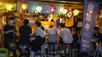 Meski begitu masih banyak ditemukan bar yang tetap buka dan ramai pelanggan meski telah melewati waktu beroperasi yang telah ditentukan. AP Photo/Kiichiro Sato.  