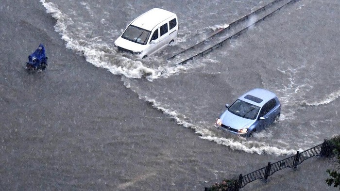 In this photo released by Xinhua News Agency, vehicles pass through floodwaters in Zhengzhou in central Chinas Henan Province on Tuesday, July 20, 2021. At least a dozen people died in severe flooding Tuesday in a Chinese provincial capital that trapped people in subways and schools, washed away vehicles and stranded people in their workplaces overnight. (Zhu Xiang/Xinhua via AP)