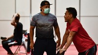 Lifter Eko Yuli Irawan (kanan) yang akan berlaga dikelas 61 Kg Olimpiade Tokyo 2020 berbincang dengan pelatih Erwin Abdullah saat berlatih di Hall Tokyo International Forum, Tokyo, Jepang.