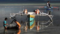 Anak-anak bermain di tepi pantai saat air laut surut di Pulau Kinabuhutan, Minahasa Utara, Sulawesi Utara. ANTARA FOTO/ADWIT B PRAMONO
