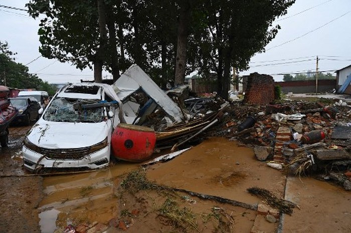 Damaged cars and debris are seen on a muddy road after severe flooding and landslide in recent days have hit the county-level Gongyi city, near Zhengzhou, in central Chinas Henan province on July 22, 2021. (Photo by JADE GAO / AFP)