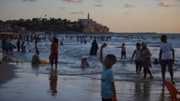 Warga Palestina berbaur dengan warga Israel di pantai Tel Aviv. AP Photo/Oded Balilty.  