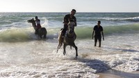 Selain di Tel Aviv, sebagian masyarakat menikmati libur Idul Adha dengan berkuda di Pantai Zikim yang berada di perbatasan Israel-Gaza. AP Photo/Tsafrir Abayov.