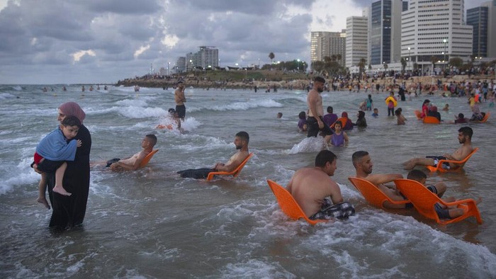 Libur Idul Adha dimanfaatkan sebagian warga Palestina dengan berwisata ke pantai di Tel Aviv, Israel. Begini momennya.