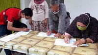 Sejumlah pedagang tampak mengisi formulir. Mereka juga membawa nomor antrian.