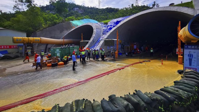 Rescuers build embankments to pump out water from a flooded tunnel in Zhuhai city in south Chinas Guangdong province Friday, July 16, 2021. Divers have been dispatched in the search for 14 workers missing since water flooded a tunnel under construction in southern China three days ago, authorities said Sunday, July 18, 2021. (Chinatopix via AP)