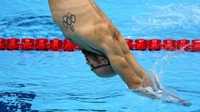 Seorang perenang mengikuti sesi latihan renang di Tokyo Aquatics Center pada Olimpiade Tokyo 2020, di Tokyo, Jepang. Tampak tattoo bergambar logo Olimpiade di dada sebelah kanan perenang tersebut. AP Photo/Martin Meissner.