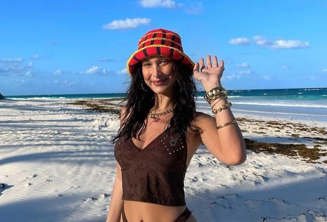 Selanjutnya ada Bella Hadid. Supermodel Hollywood yang merupakan adik dari Gigi Hadid ini juga memilih untuk mengenakan bucket hat rajut yang ternyata merupakan karya Delsy Gouw. Bucket hat rajut berwarna merah dengan garis hitam dan kuning itu dipadukannya dengan bikini berwarna coklat. Untuk melengkapi penampilannya, Bella tampak menambahkan aksesori berupa anting, kalung, gelang, dan juga cincin. Foto: dok. instagram.com/its_memorialday