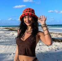 Selanjutnya ada Bella Hadid. Supermodel Hollywood yang merupakan adik dari Gigi Hadid ini juga memilih untuk mengenakan bucket hat rajut yang ternyata merupakan karya Delsy Gouw. Bucket hat rajut berwarna merah dengan garis hitam dan kuning itu dipadukannya dengan bikini berwarna coklat. Untuk melengkapi penampilannya, Bella tampak menambahkan aksesori berupa anting, kalung, gelang, dan juga cincin. Foto: dok. instagram.com/its_memorialday