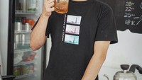 Ini salah satu posenya saat berada di kedai kopinya yang sederhana. Tak hanya es kopi susu, tapi juga tersedia es lemon tea yang segar. Foto: Instagram @arbaniyasiz