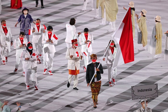 Gaya Defile Indonesia di Upacara Pembukaan Olimpiade 2020 Tokyo TOKYO, JAPAN - JULY 23: Flag bearers Nurul Akmal and Rio Waida of Team Indonesia lead their team out during the Opening Ceremony of the Tokyo 2020 Olympic Games at Olympic Stadium on July 23, 2021 in Tokyo, Japan. (Photo by Patrick Smith/Getty Images)