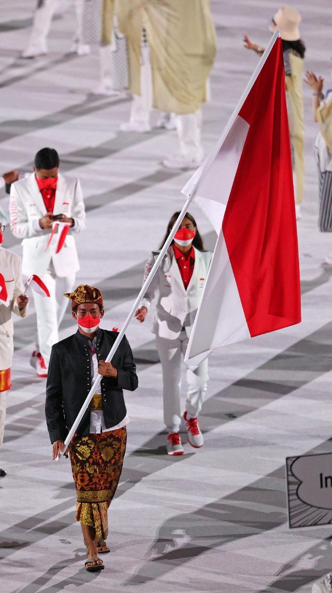 Rio Waida yang merupakan atlet surfing tampil paling depan saat parade pembukaan Olimpiade Tokyo 2020 di Jepang, Jumat (23/7/2021). Rio tampil bersahaja menggunakan Payas Madya yang merupakan pakaian adat Bali. Foto: Getty Images/Patrick Smith