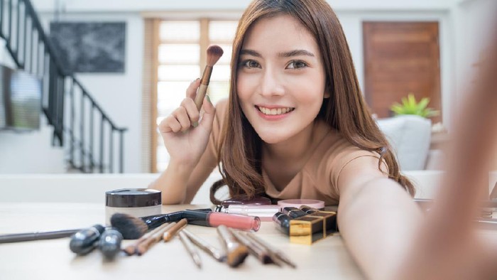 Young beautiful asian woman professional beauty vlogger or blogger recording make up tutorial to share on social media