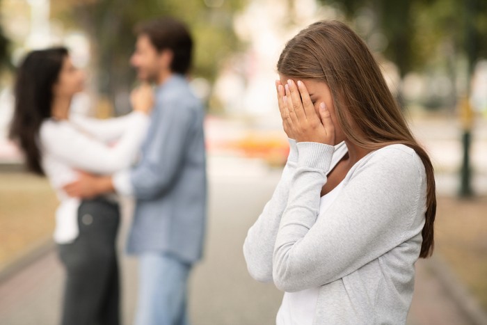 Ilustrasi selingkuh atau perselingkuhan Upset woman crying, seeing her boyfriend with other girl in park