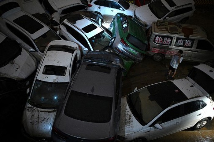 An aerial view shows cars sitting in floodwaters at the entrance of a tunnel after heavy rains hit the city of Zhengzhou in China's central Henan province on July 22, 2021. (Photo by Noel Celis / AFP)