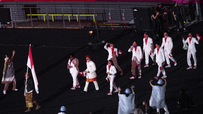 Kontingen Indonesia mengikuti defile dalam pembukaan Olimpiade Tokyo 2020 di Stadion Nasional, Tokyo, Jepang, Jumat (23/7/2021). ANTARA FOTO/Sigid Kurniawan/rwa.