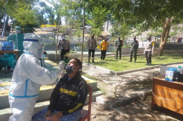 Polisi dan TNI mengawasi tes cepat antigen bagi seorang pria yang sempat ikut mengambil paksa jenazah pasien COVID-19 (ANTARA/Ho-Humas Polres Kupang Kota)