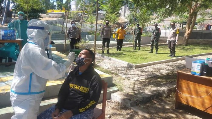 Polisi dan TNI mengawasi tes cepat antigen bagi seorang pria yang sempat ikut mengambil paksa jenazah pasien COVID-19 (ANTARA/Ho-Humas Polres Kupang Kota)