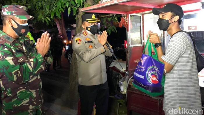 Satgas COVID-19 Banyuwangi menggelar patroli skala besar. Selain merazia pelanggar prokes, mereka juga membagikan sembako ke warga terdampak PPKM.