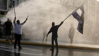 Polisi menembakkan water cannon untuk membubarkan massa aksi yang menolak vaksinasi.